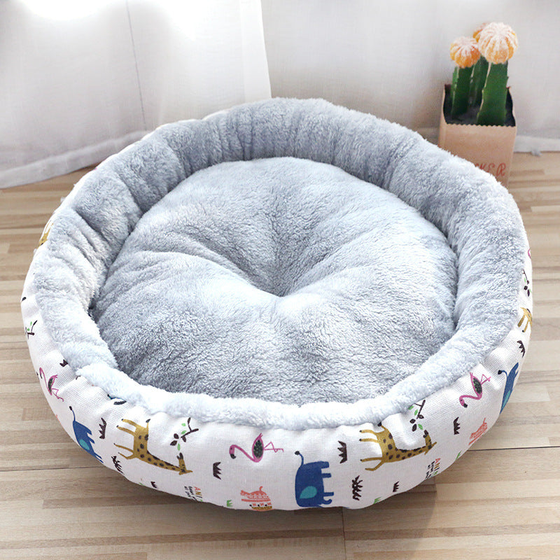 Round pet bed with cartoon animal patterns on a wooden floor.