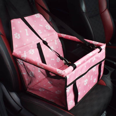 Pink pet seat cover with bone and paw pattern on a car seat