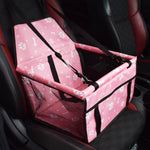 Pink pet seat cover with bone and paw pattern on a car seat