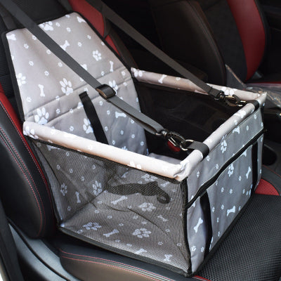 Pet car seat with straps on a car seat, featuring paw print pattern.