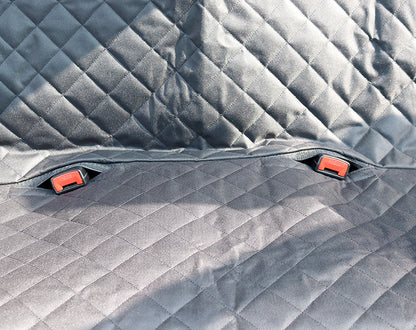 Gray quilted car mat with red clips on a textured surface of Dog Car Seat Cover