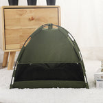 Green pet tent on a white surface with a wooden drawer in the background