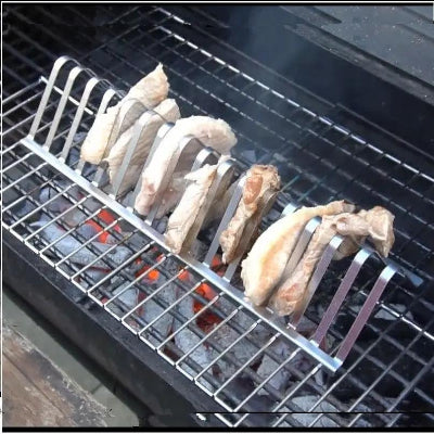 Metal grill rack with chicken wings on a barbecue grill