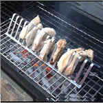 Metal grill rack with chicken wings on a barbecue grill