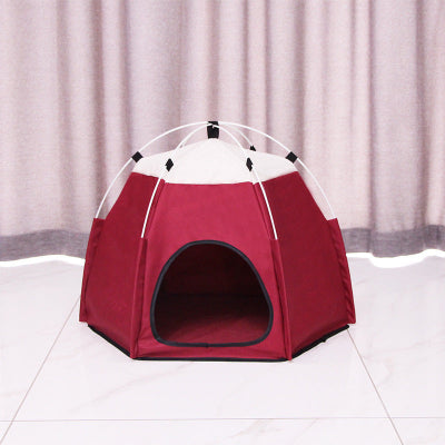 Red pet tent with white top on a light gray floor and curtain background