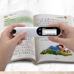 Hand holding a portable device over an open book with text and images.