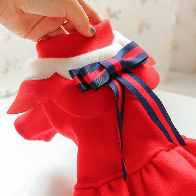 Red dress with a navy blue ribbon held by a hand against a blurred background