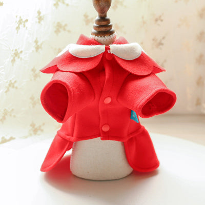 Red felt coat with white collar on a white cushion against a beige background