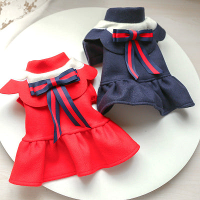 Red and navy dog dresses with bows on a white plate