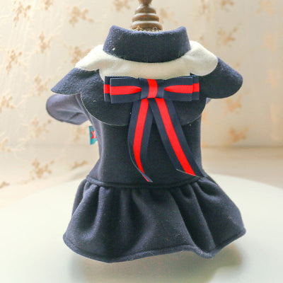 Navy blue pet dress with a red bow on a mannequin against a neutral background