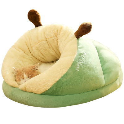Cat sleeping in a green and beige snail-shaped pet bed on a white background