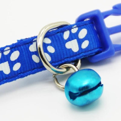 Blue pet collar with white paw prints and a blue bell on a white background