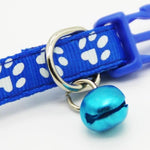 Blue pet collar with white paw prints and a blue bell on a white background