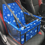 Blue pet seat cover with paw and bone patterns installed in a car.