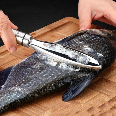 Fish scaler being used on a fish on a wooden cutting board