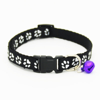 Black cat collar with white paw prints and a purple bell on a white background