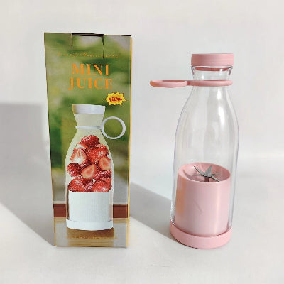 Pink and clear mini juice maker with packaging featuring a glass bottle filled with strawberries.
