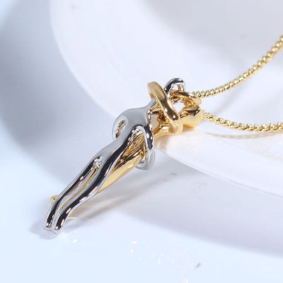Gold and silver pendant on a chain against a white background