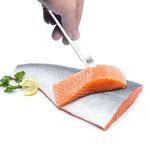 Raw salmon fillet with a lemon wedge and herbs on a white background