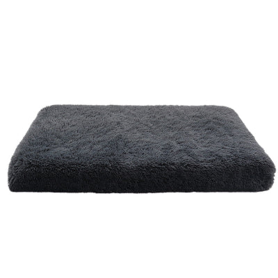 Dark gray fluffy cushion on a white background
