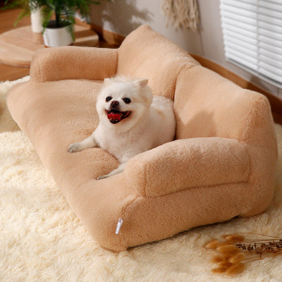 Dog lying on a beige pet bed in a cozy room with a plant and window blinds.