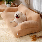 Dog lying on a beige pet bed in a cozy room with a plant and window blinds.