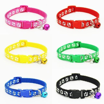 Set of colorful cat collars with paw pattern and bell on a white background