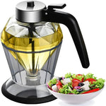 Glass oil dispenser with black handle next to a bowl of salad on a white background