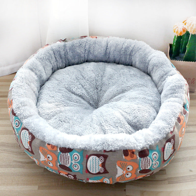 Round pet bed with owl pattern on a wooden floor
