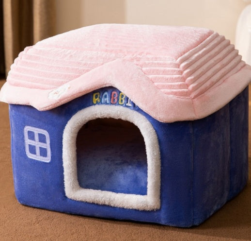 Blue pet house with pink roof on a brown surface