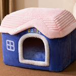 Blue pet house with pink roof on a brown surface