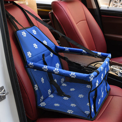 Blue pet seat cover with white paw prints on a car seat