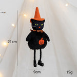 Black cat toy with Halloween decorations on a white background