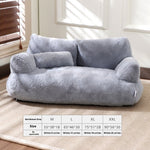 Gray pet bed with size chart on a carpeted floor