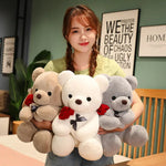 Woman holding three teddy bears of different colors in a room with decor elements.