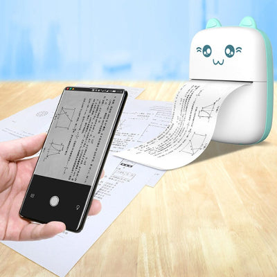 Small printer with cartoon design next to a smartphone displaying text on a piece of paper.