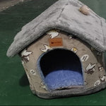 Gray pet house with cartoon designs on a green surface