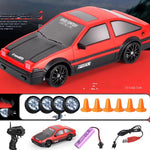 Red toy car with black details on a red background, accompanied by remote control, lights, and cones.