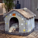 Dog lying in a star-patterned pet house on a carpeted floor.