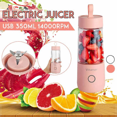 Pink electric juicer with fruits and juice splashes on a wooden surface
