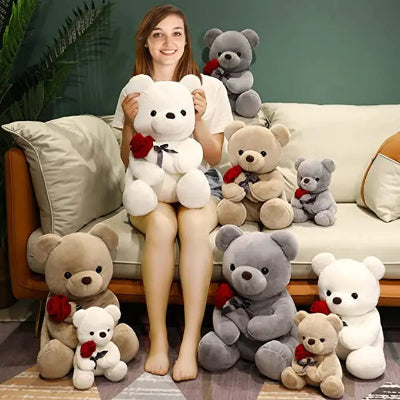 Woman holding a large white teddy bear with smaller teddy bears around her on a couch.