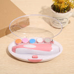Pink nail drill with colorful attachments in a clear case on a wooden surface.