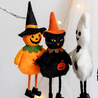 Halloween-themed plush toys including a pumpkin, black cat, and ghost on a light background.