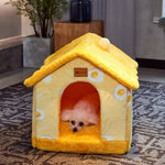 Yellow pet house with a small dog inside on a patterned rug.