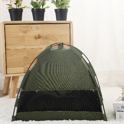 Green pet tent on a white surface with a wooden dresser and potted plants in the background.