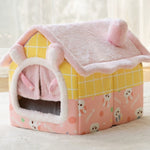 Pink and yellow pet house with cartoon designs on a light background