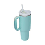 Turquoise mug with handle and straw lid on a white background