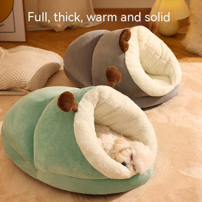 Two pet beds, one green and one gray, with a small dog inside the green bed on a wooden floor.