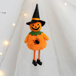 Halloween-themed plush toy with pumpkin face, black spider, and witch hat on a white background.