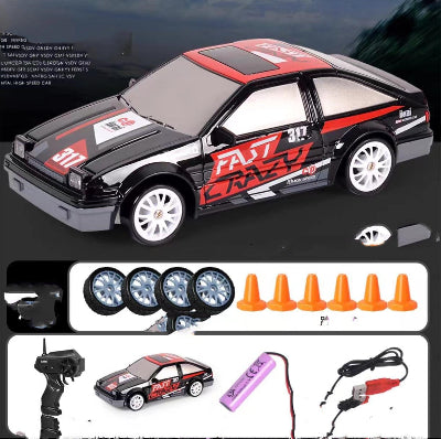 Toy car with racing decals, remote control, batteries, and cones on a dark background
